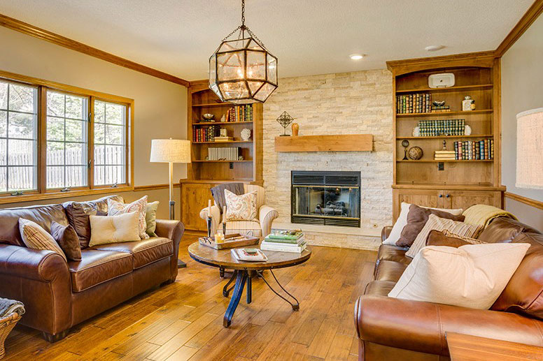 Living room remodeled with wood floor, brickwork, built-in bookshelves and leather furniture