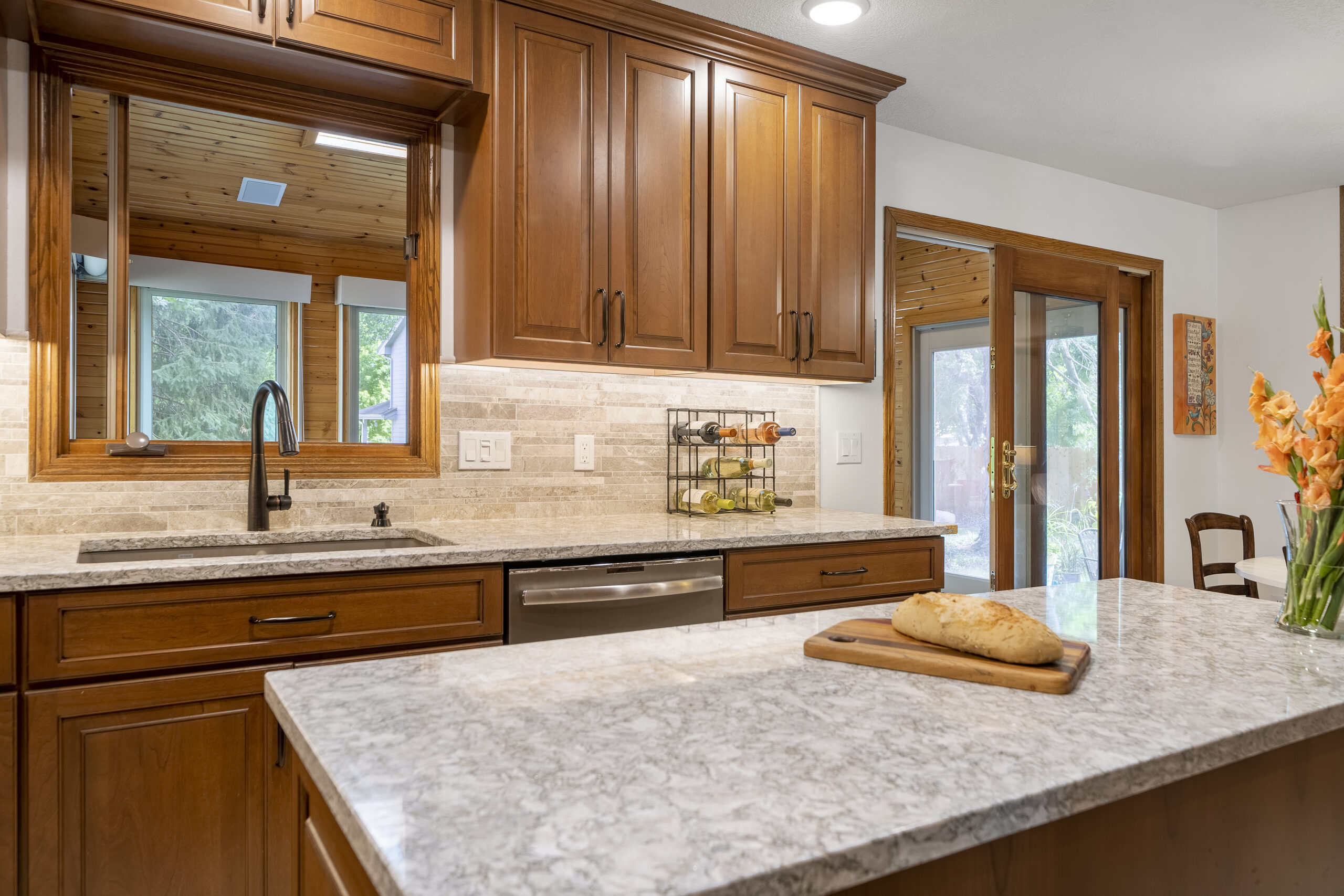 This is an Urbandale remodel in a traditional home which features wood cabinets and quartz countertops.
