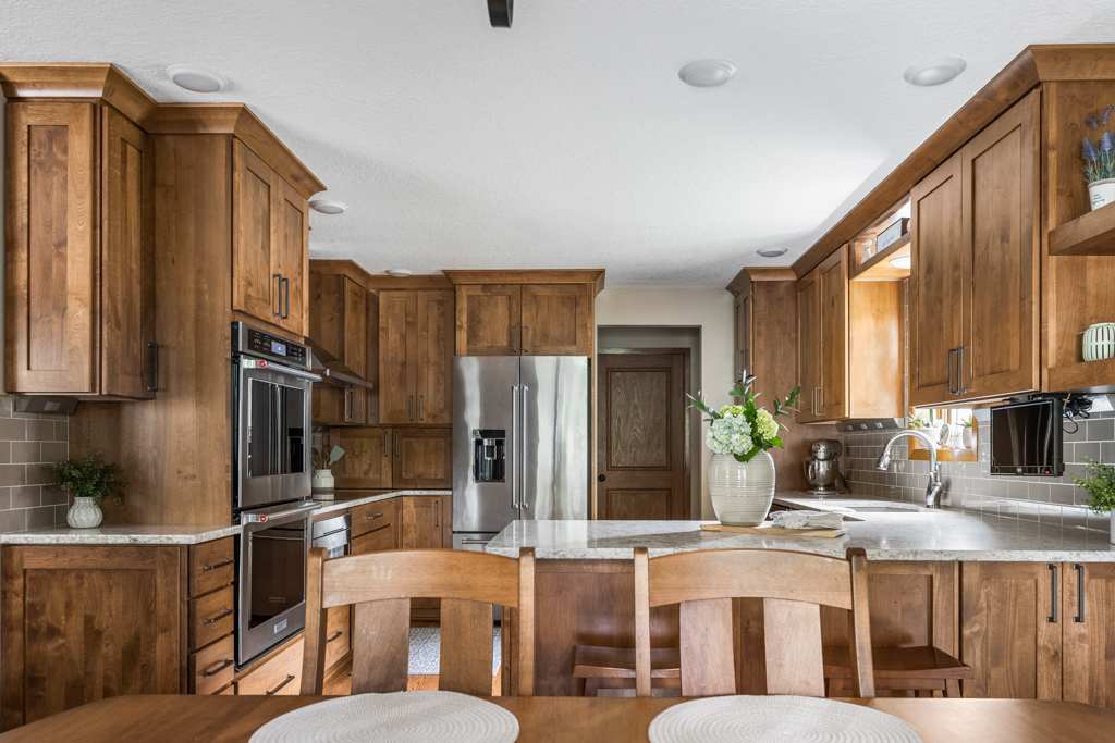 Indianola kitchen remodel that has wood cabinetry, built in ovens and quartz tops.