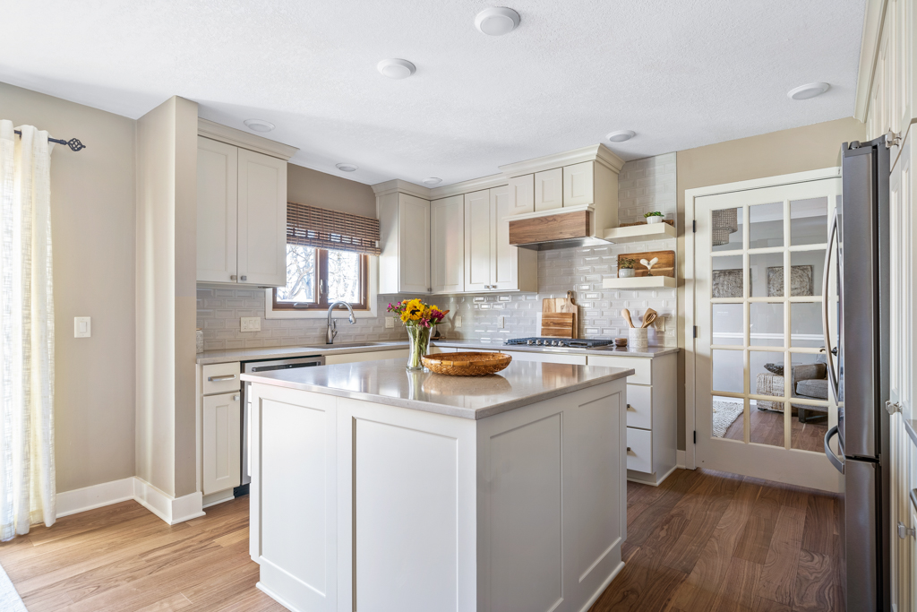 West Des Moines kitchen remodel featuring neutral cabinets, island and french door.